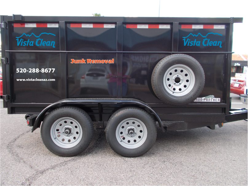 A black trailer with the words " junk removal " on it.