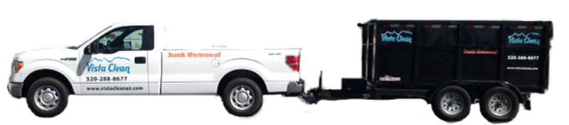 A white truck with its bed pulled by a trailer.