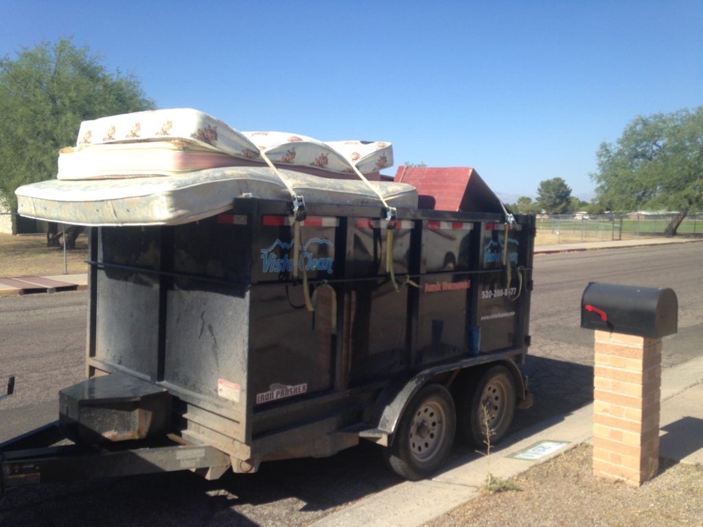 A trailer with two beds on it and some boxes in the back.