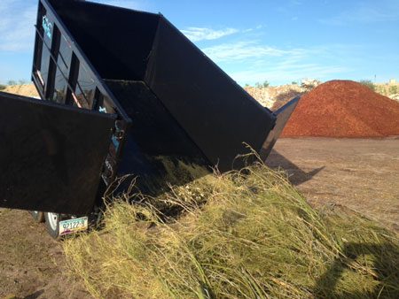 A black box sitting in the grass next to some dirt.