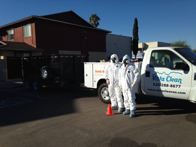 Two people in white suits standing next to a truck.