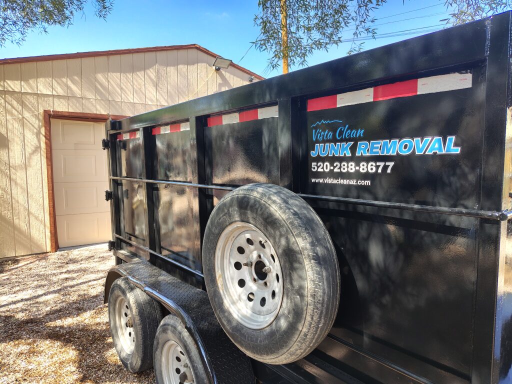 a picture of a vista clean junk removal trailer on a property with a house and garage in the background