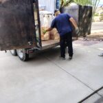 Vista Clean Junk Removal owner Ken loading a box into a trailer.
