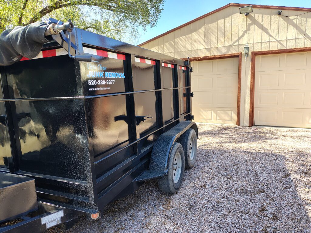 Vista Clean junk removal trailer backed up to a garage ready to get loaded from a property eviction cleanout.