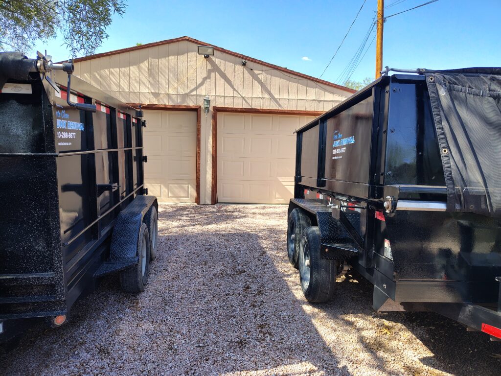 two Vista Clean dump trailers in front of a garage